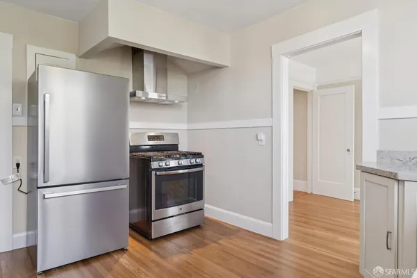 a kitchen with wooden floors and stainless steel appliances