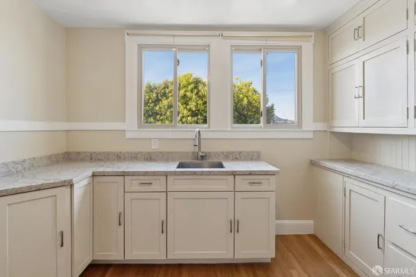 a sink with cabinets and wooden floor