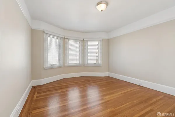 a view of an empty room with wooden floor