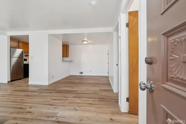a view of a room with wooden floor and white walls