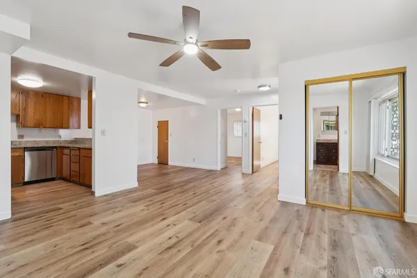a view of empty room with wooden floor and ceiling fan