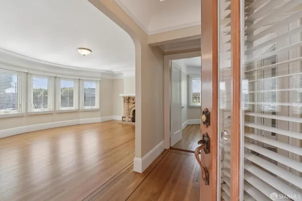 a view of a room with wooden floor and a bathroom