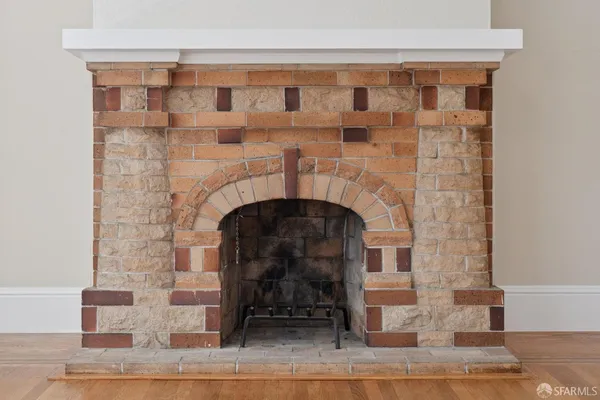 a stone fireplace with a table and chairs