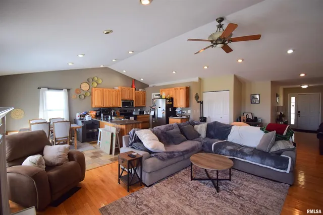 a living room with furniture kitchen view and a large window