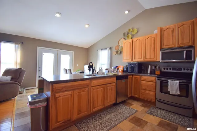 a kitchen with sink a counter top space and living room
