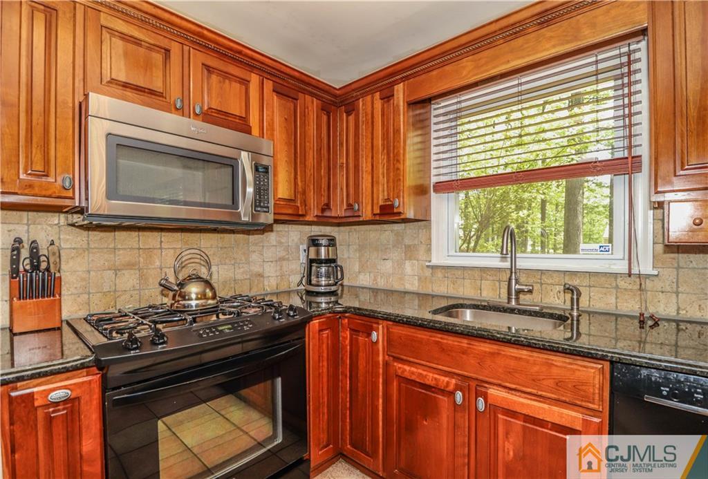 31 Sherwood Road Edison, NJ 08820 - Photo 8 of 25 a kitchen with granite countertop a stove sink and cabinets