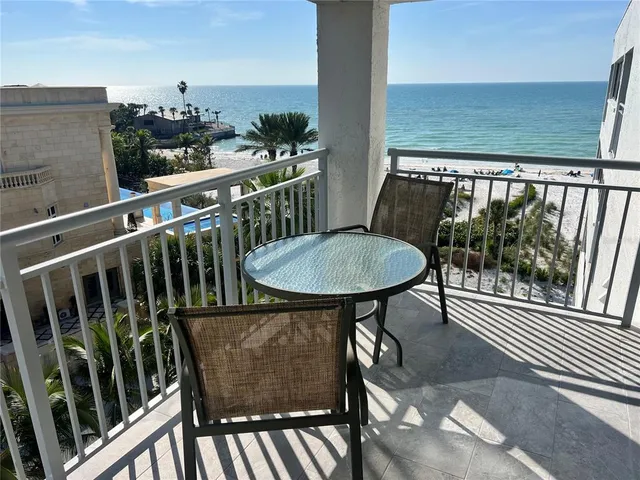 a view of a balcony with chairs and wooden floor