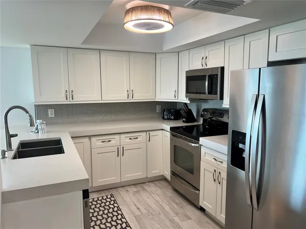 a kitchen with stainless steel appliances a stove a sink and a refrigerator