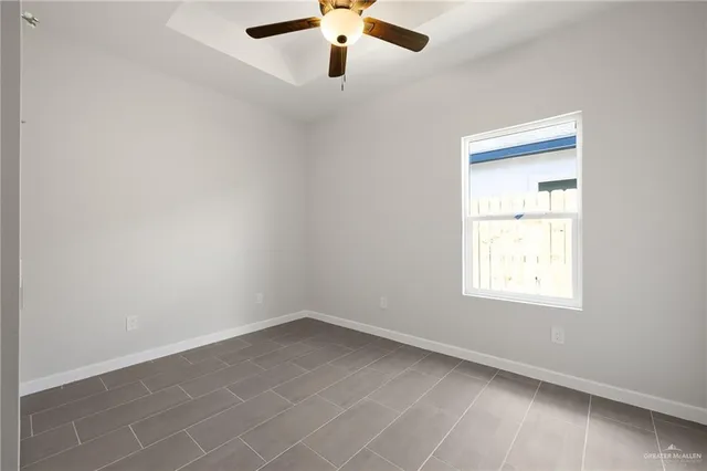 an empty room with a window and a fan