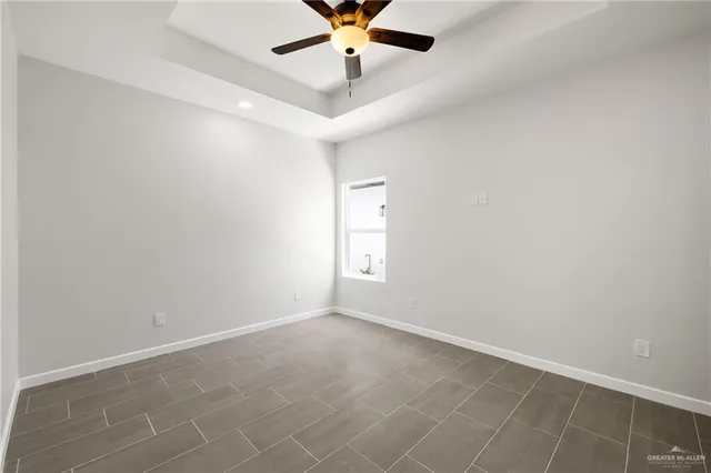 an empty room with window and ceiling fan
