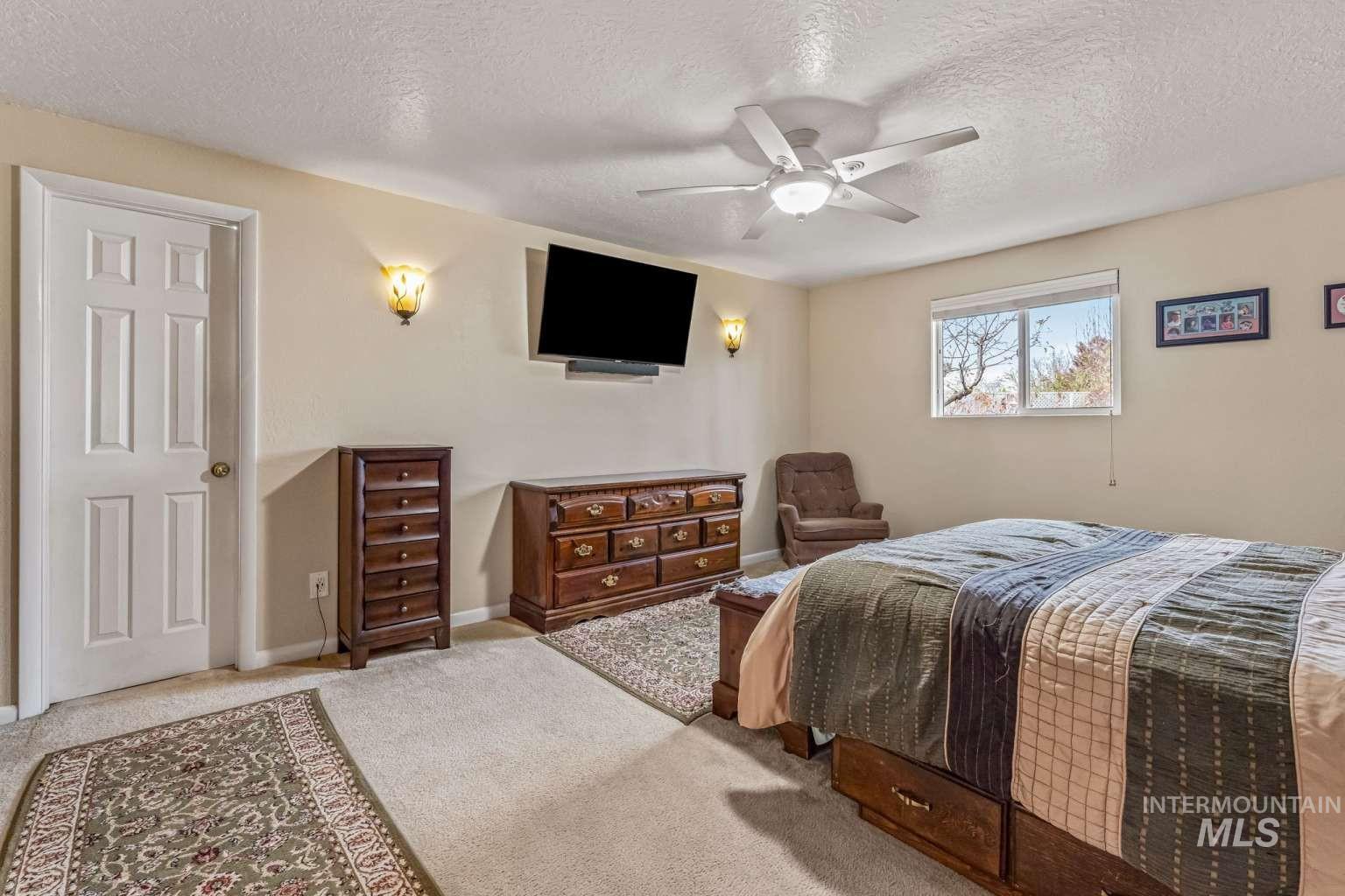 8720 Cornwall Drive Boise, ID 83704 - Photo 11 of 24 Bedroom with a textured ceiling, a ceiling fan, and carpet