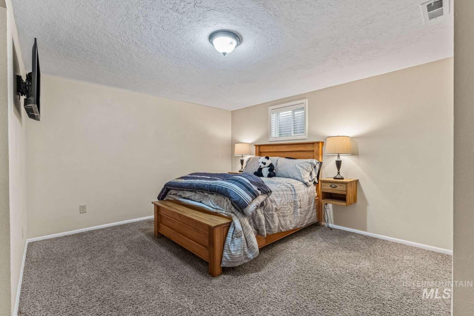 8720 Cornwall Drive Boise, ID 83704 - Photo 15 of 24 Carpeted bedroom featuring a textured ceiling and baseboards