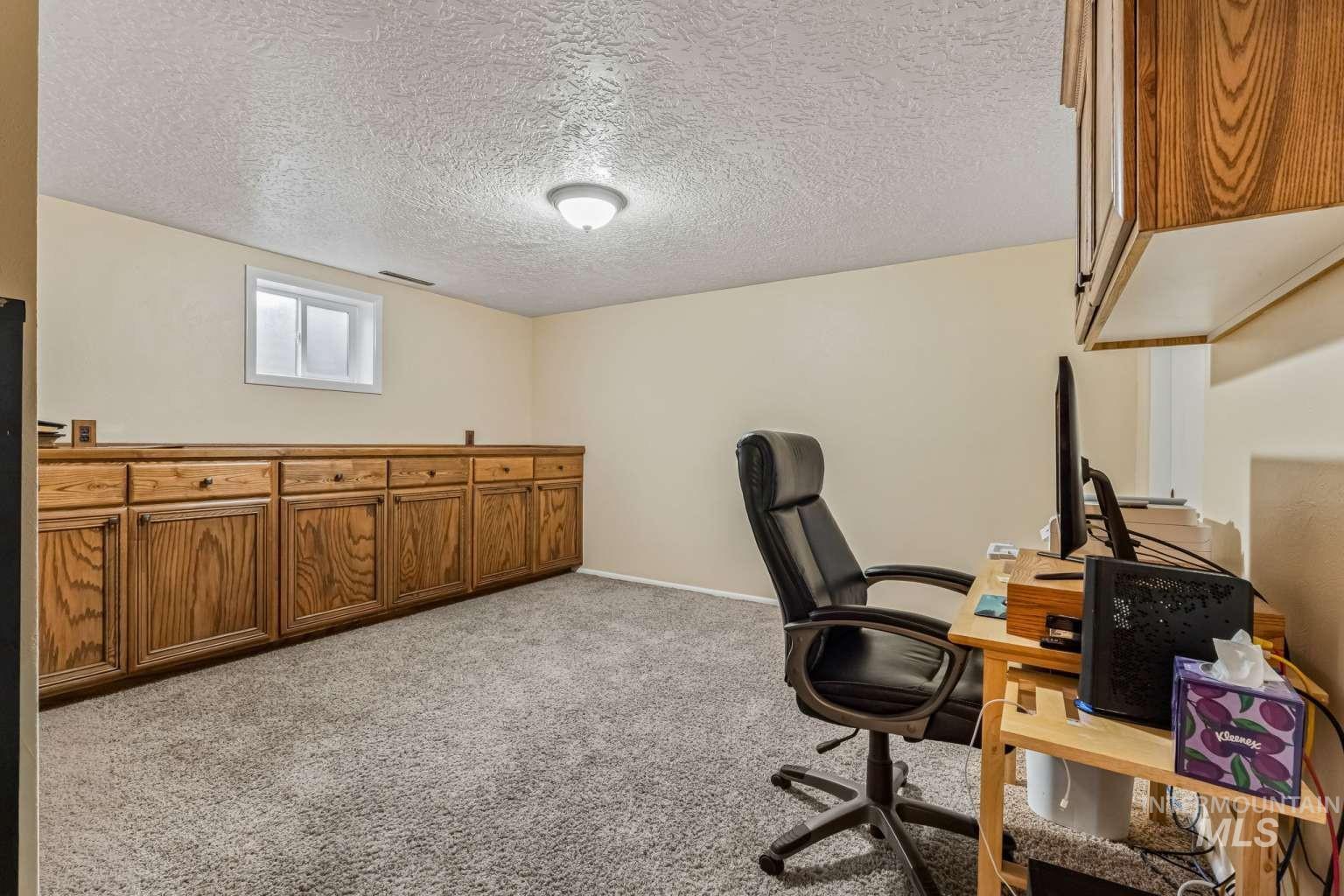 8720 Cornwall Drive Boise, ID 83704 - Photo 16 of 24 Office area with light carpet and a textured ceiling
