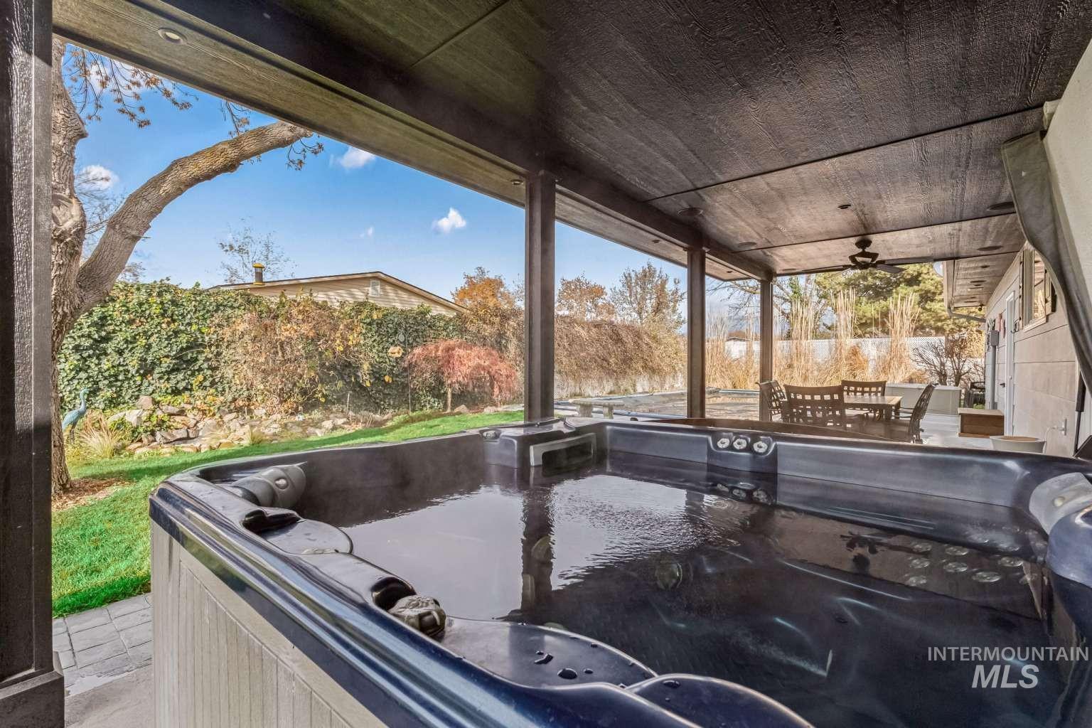 8720 Cornwall Drive Boise, ID 83704 - Photo 22 of 24 Fenced backyard with outdoor dining space, a hot tub, ceiling fan, and a patio