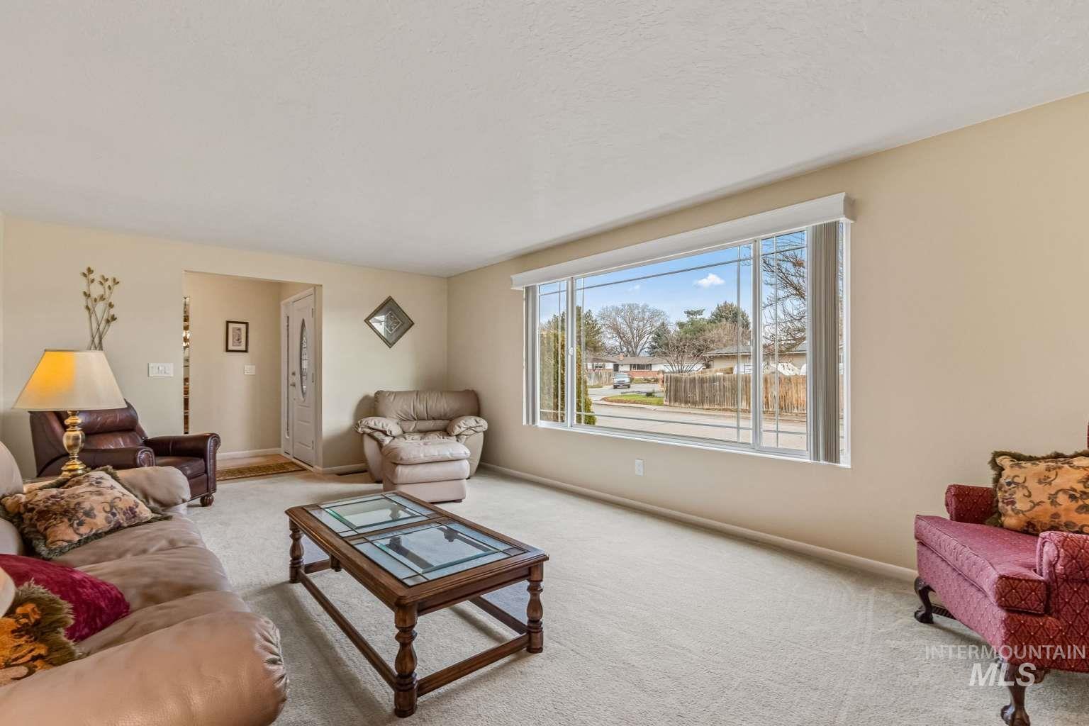 8720 Cornwall Drive Boise, ID 83704 - Photo 6 of 24 Carpeted living area with baseboards and a textured ceiling
