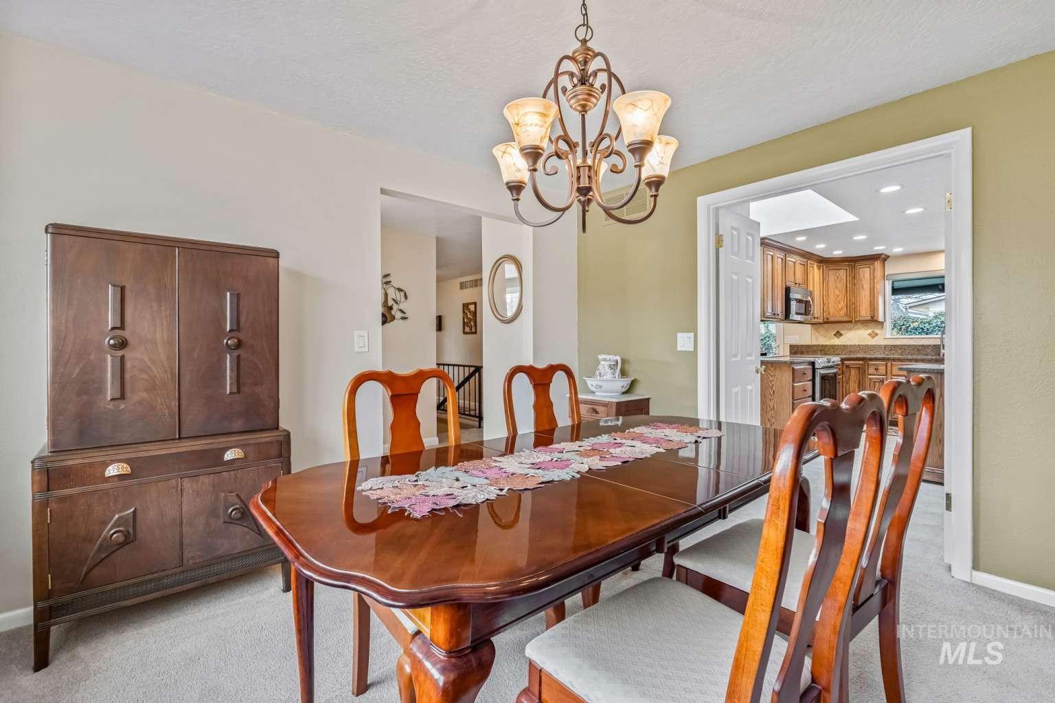 8720 Cornwall Drive Boise, ID 83704 - Photo 7 of 24 Dining space featuring light carpet, a chandelier, a textured ceiling, and recessed lighting
