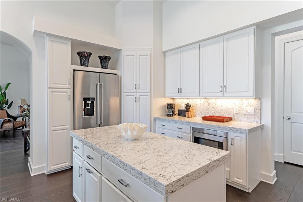 2540 Half Moon Walk Naples, FL 34102 - Photo 11 of 35 a kitchen with stainless steel appliances cabinets and wooden floor