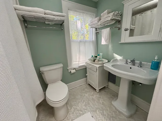 a bathroom with a sink toilet and mirror