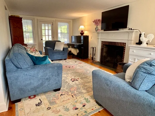 a living room with furniture a flat screen tv and a fireplace