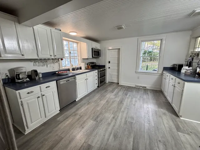 a kitchen with granite countertop a stove top oven sink and cabinets