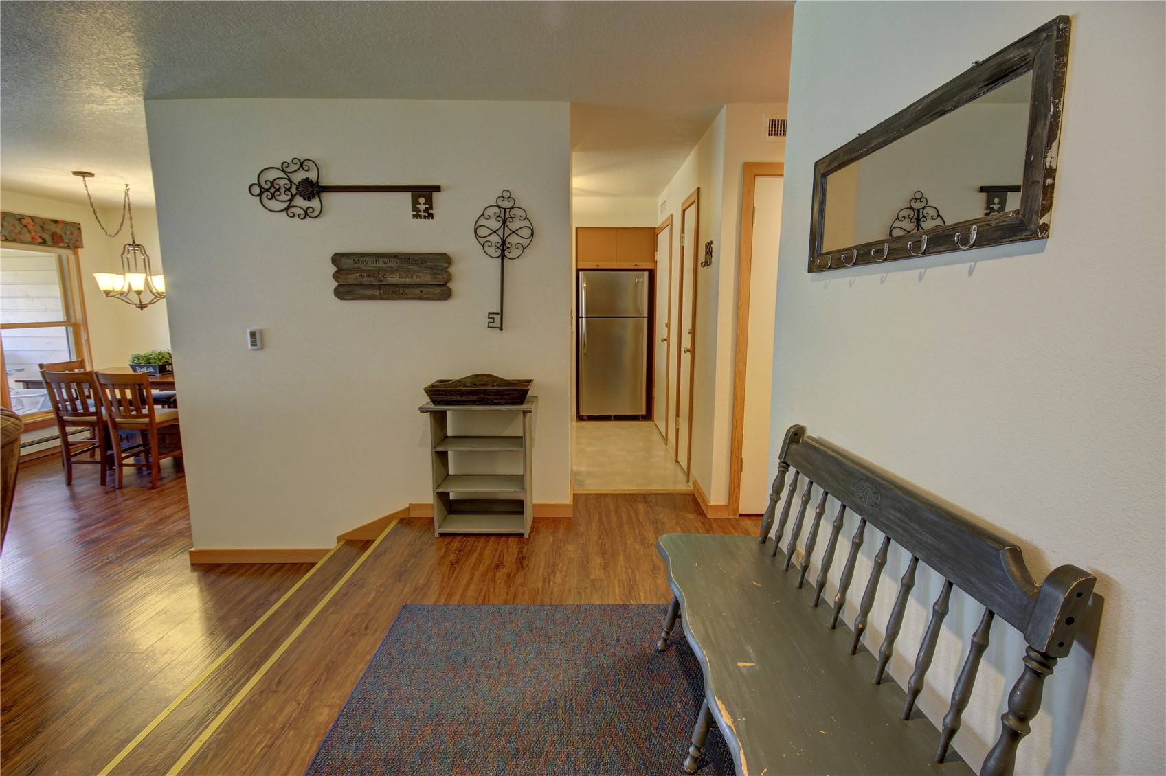 Corridor with a textured ceiling, hardwood / wood-style flooring, and an inviting chandelier