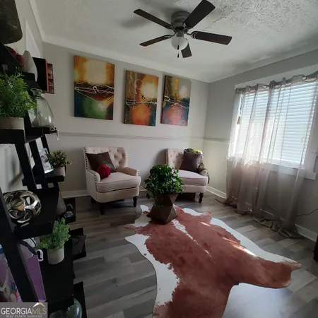 a living room with furniture floor to ceiling window and potted plant