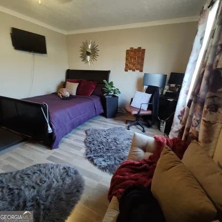 a bedroom with furniture and a flat screen tv