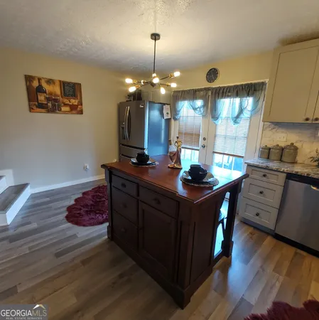 a kitchen with granite countertop a sink cabinets and wooden floor