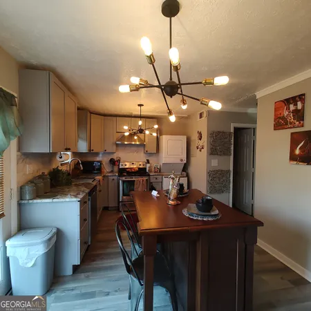 a kitchen with a dining table chairs stainless steel appliances and cabinets