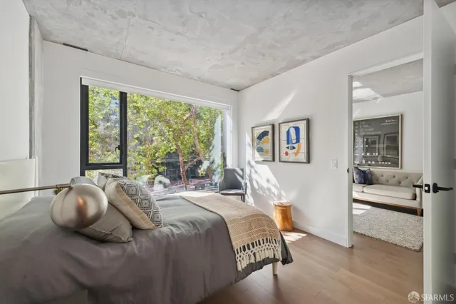 a bedroom with a bed and wooden floor