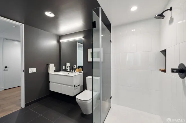 a bathroom with a sink vanity mirror and toilet