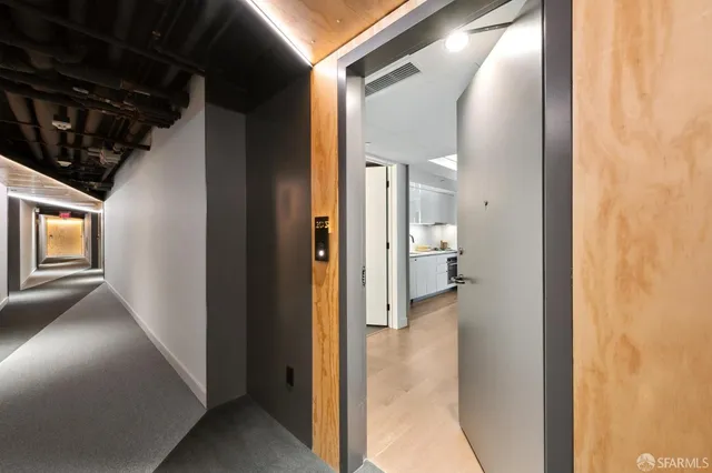 a view of a hallway with toilet and a bathroom