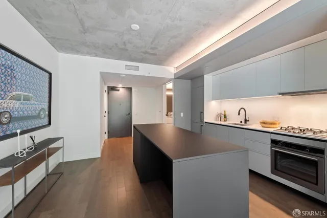 a kitchen with stainless steel appliances granite countertop a sink a stove and a wooden floors