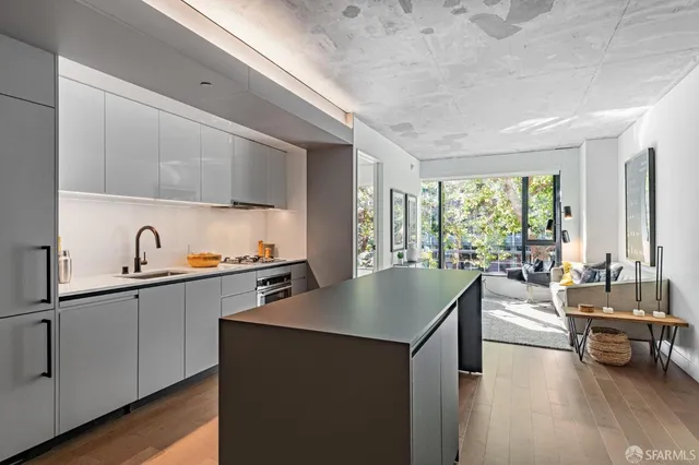 a kitchen with sink and view of living room