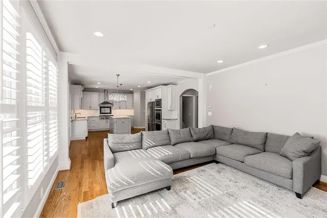 a living room with furniture white walls and a large window