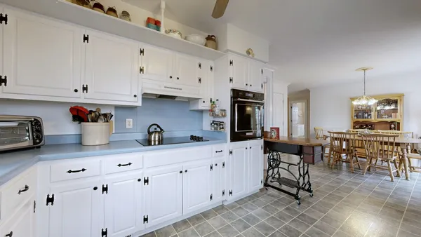 a dining room with furniture a chandelier and wooden floor