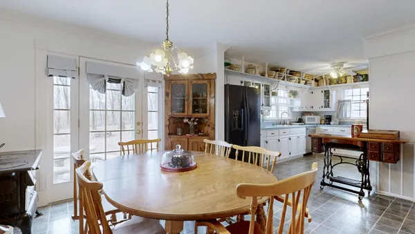 a living room with couches and dresser with wooden floor