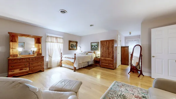 a view of a hallway with wooden floor and stairs