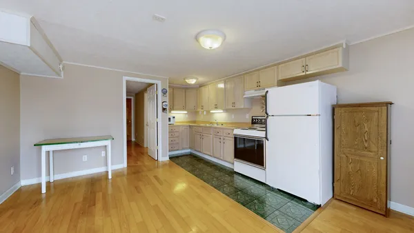 a backyard of a house with large trees and wooden fence