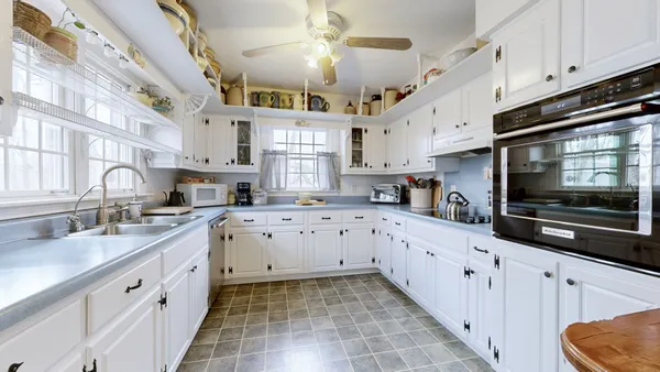 a kitchen with cabinets and chairs in it