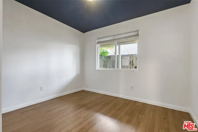 a view of a kitchen with wooden floor and electronic appliances