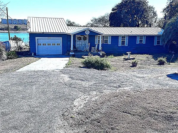 a front view of a house with yard and parking space