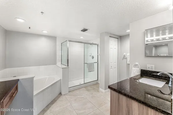 a bathroom with a tub shower and sink