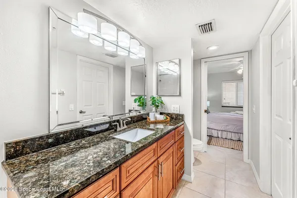 a bathroom with a granite countertop sink and a mirror