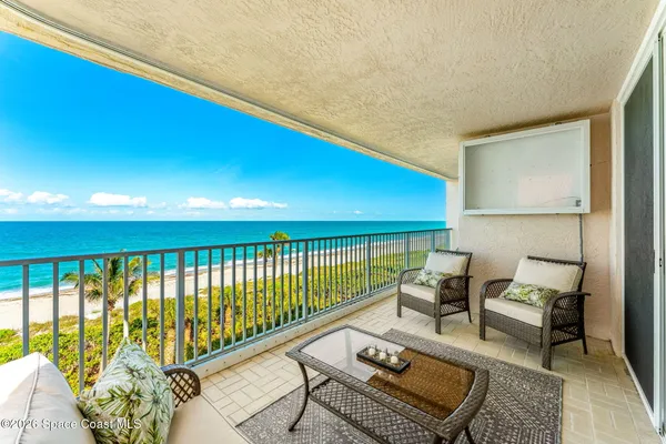 a balcony with wooden floor and furniture