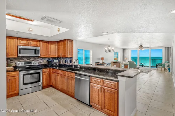 a kitchen with stainless steel appliances granite countertop a stove a sink and a microwave