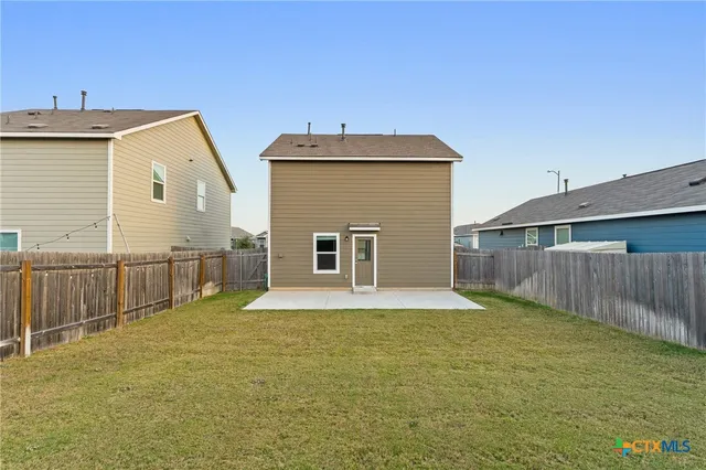 a view of a backyard with wooden fence