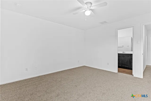 an empty room with a ceiling fan and window