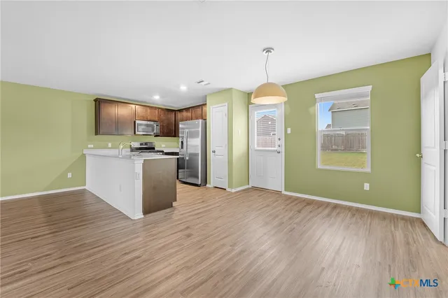 a view of a kitchen with a sink wooden floor and a window