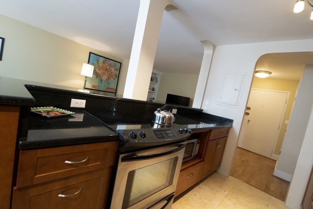 131 Sewall Avenue, Unit 37 Brookline, MA 02446 - Photo 12 of 27 a kitchen with stainless steel appliances granite countertop a stove and a microwave